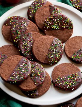 Chocolate Shortbread Cookies coated halfway in chocolate coating and covered with sprinkles.