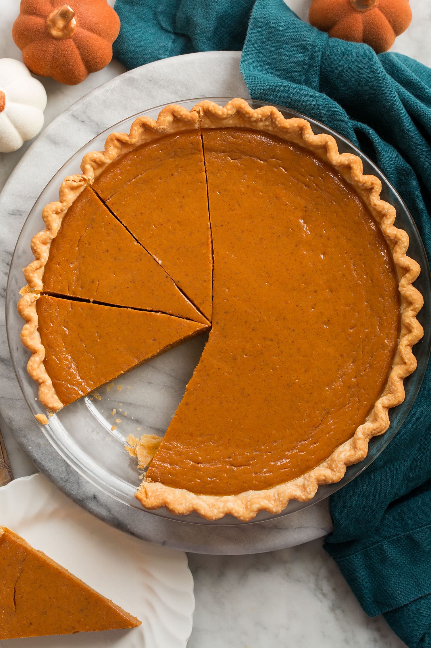 Overhead image of pumpkin pie in pie pan sliced.