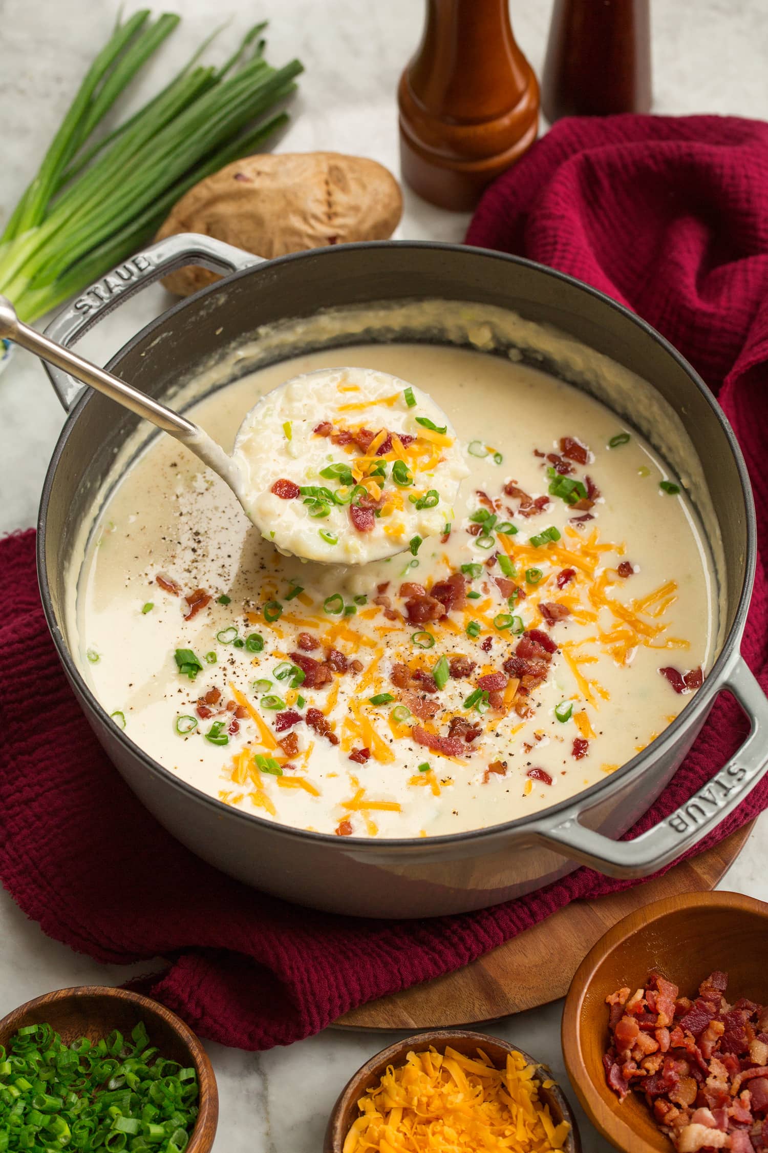 Soup pot with baked potato soup and garnishes. 