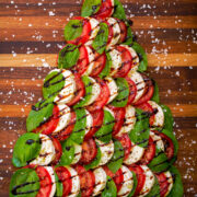 Caprese Christmas tree with fresh mozzarella, tomato slices, fresh basil leaves, balsamic glaze and sea salt flakes.