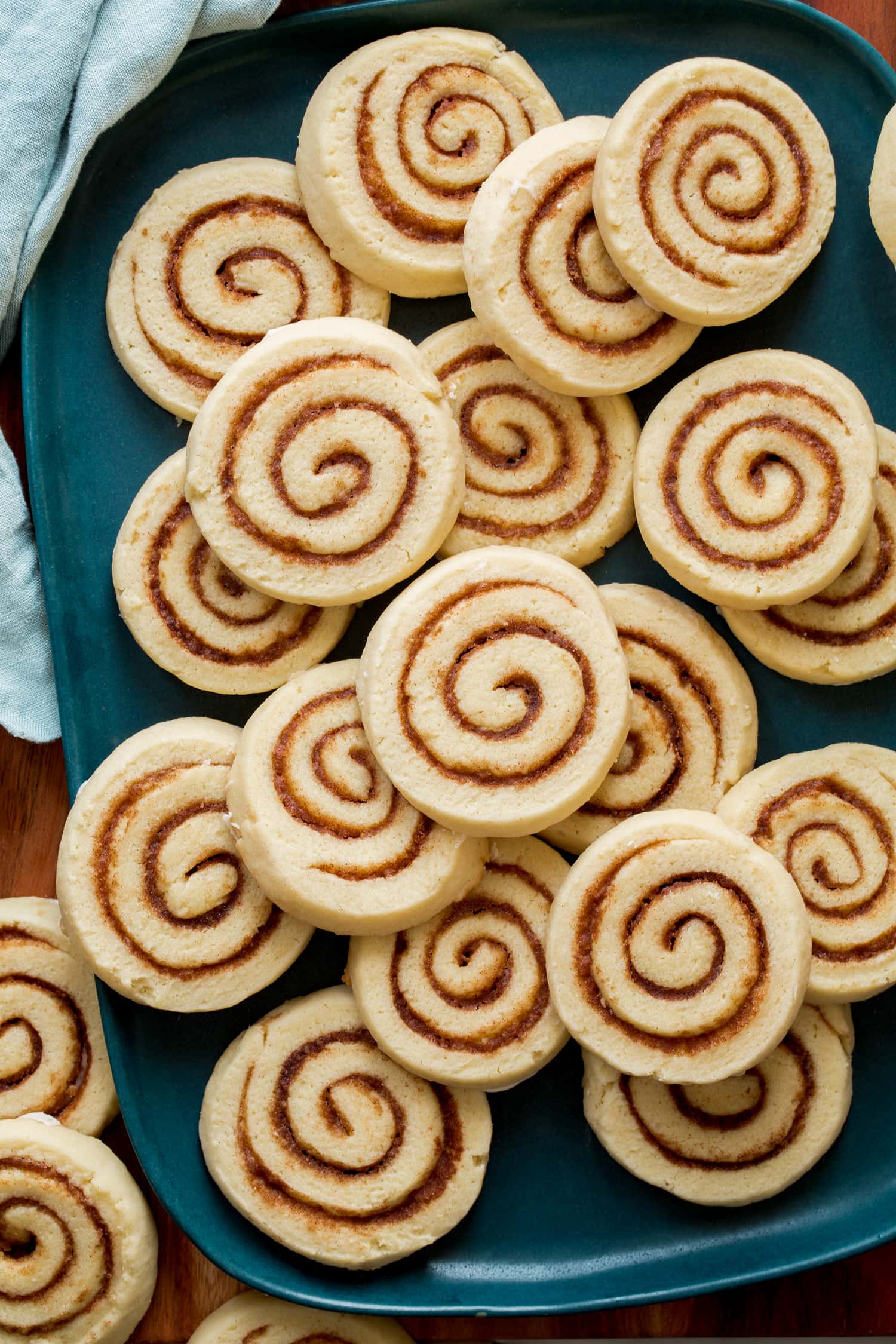 Cinnamon Roll cookies shown close up on a blue turquoise platter.