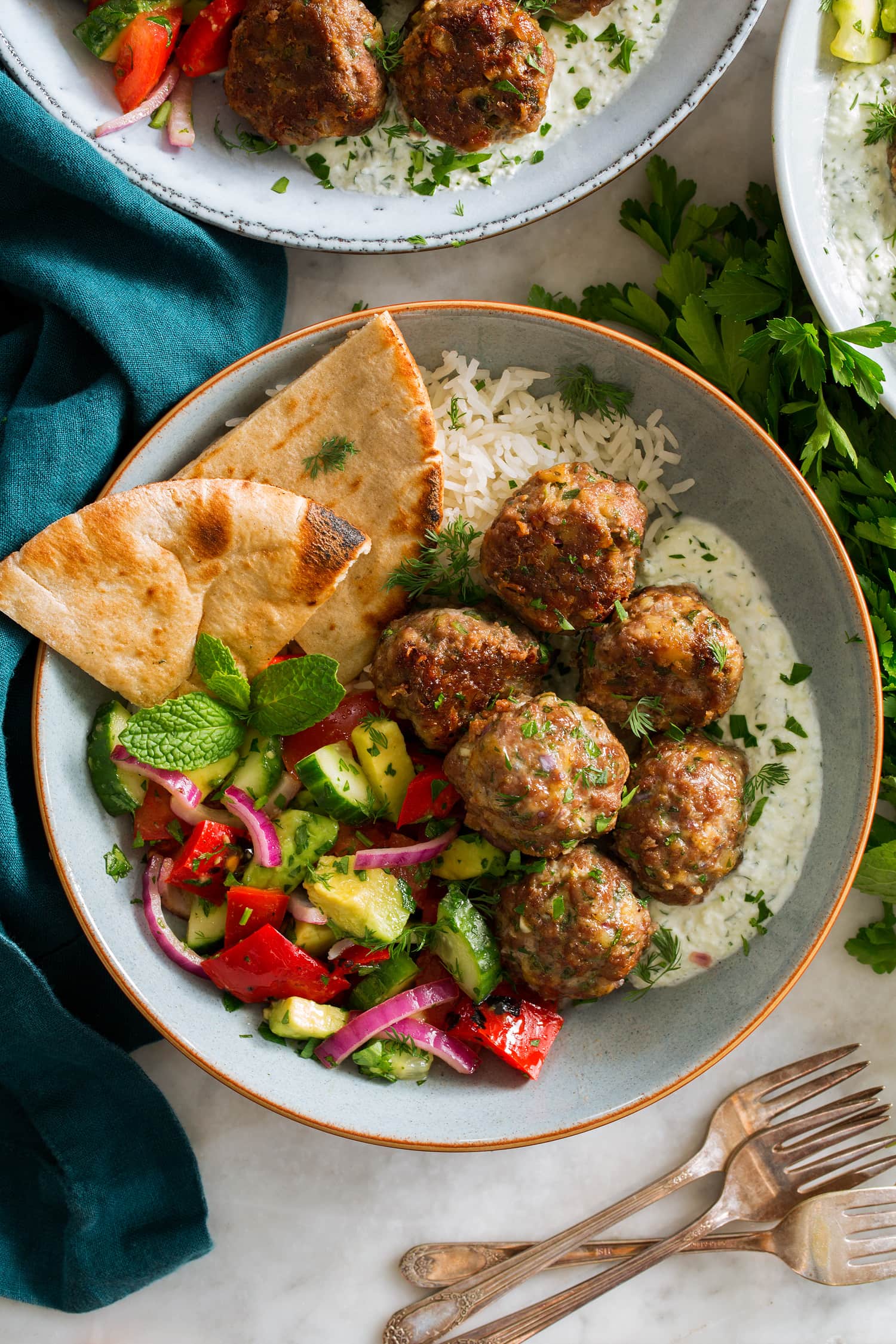 Greek meatballs in a serving bowl shown from above.