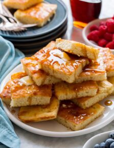 Stack of sheet pan pancakes with butter and syrup.