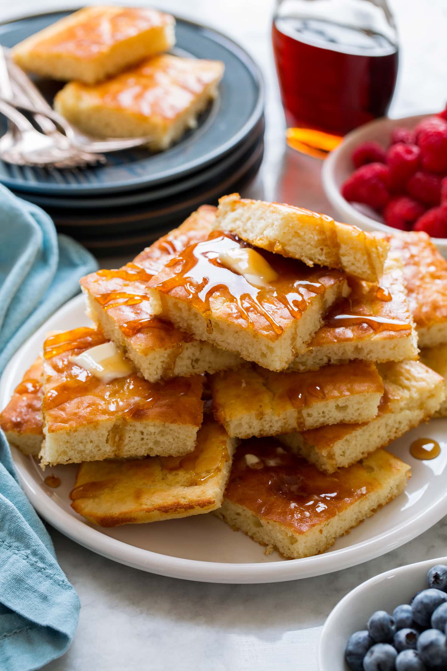 Stack of sheet pan pancakes with butter and syrup.