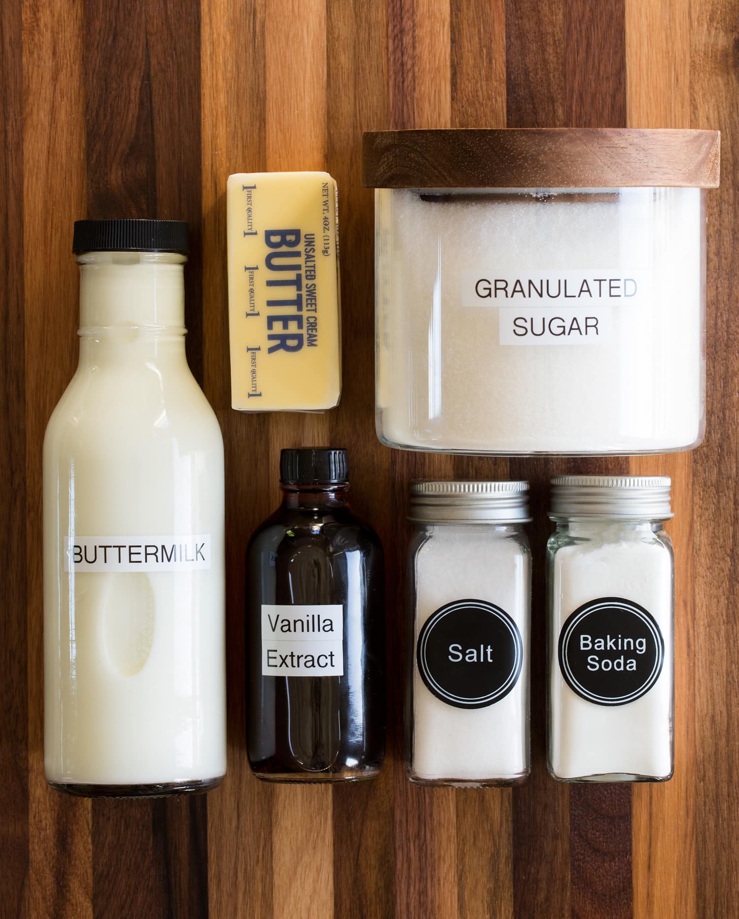 Ingredients needed to make buttermilk syrup shown including sugar, buttermilk, baking soda, salt, vanilla and butter.