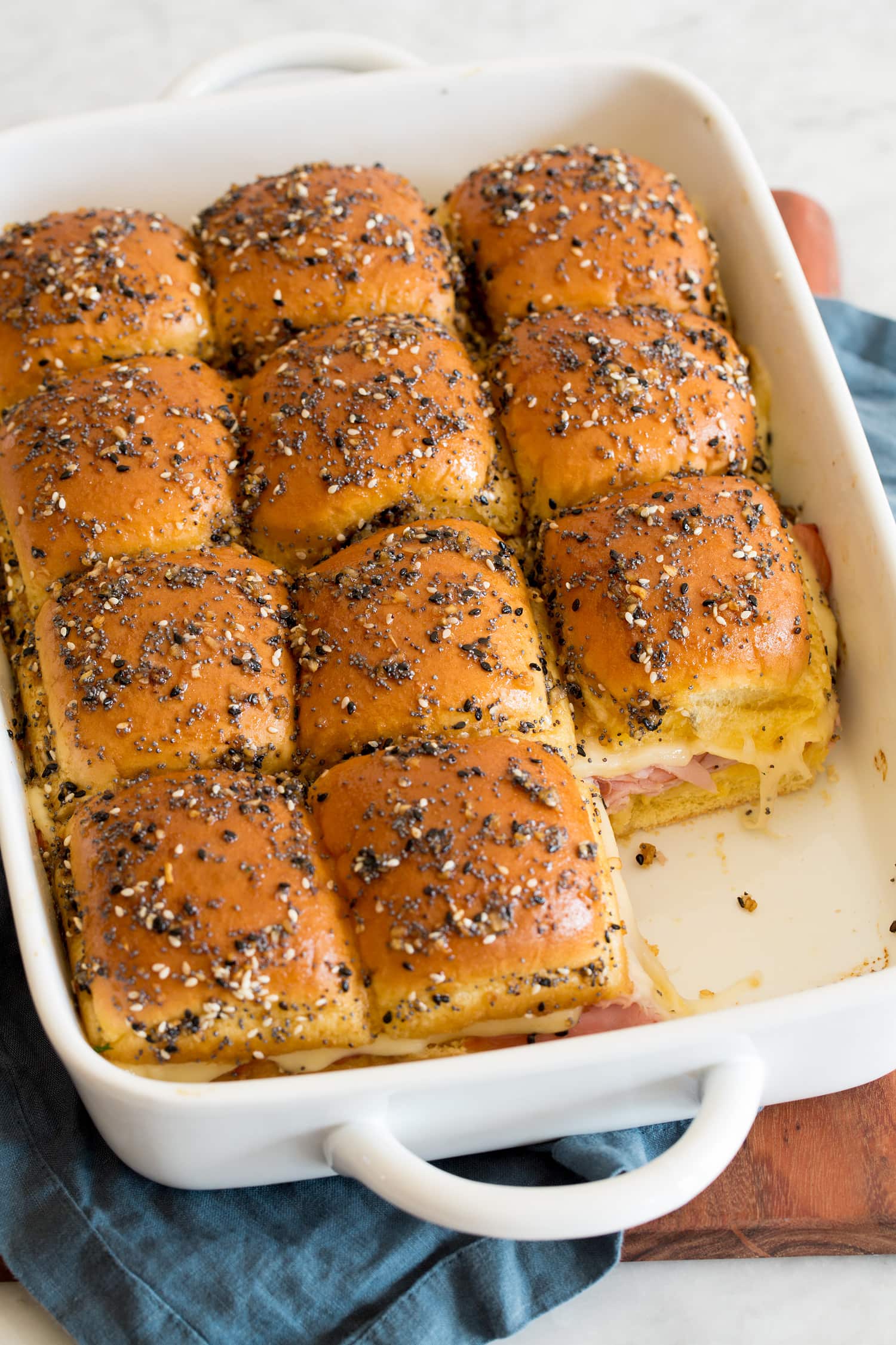Ham and swiss cheese sliders shown after baking in baking dish with one removed.