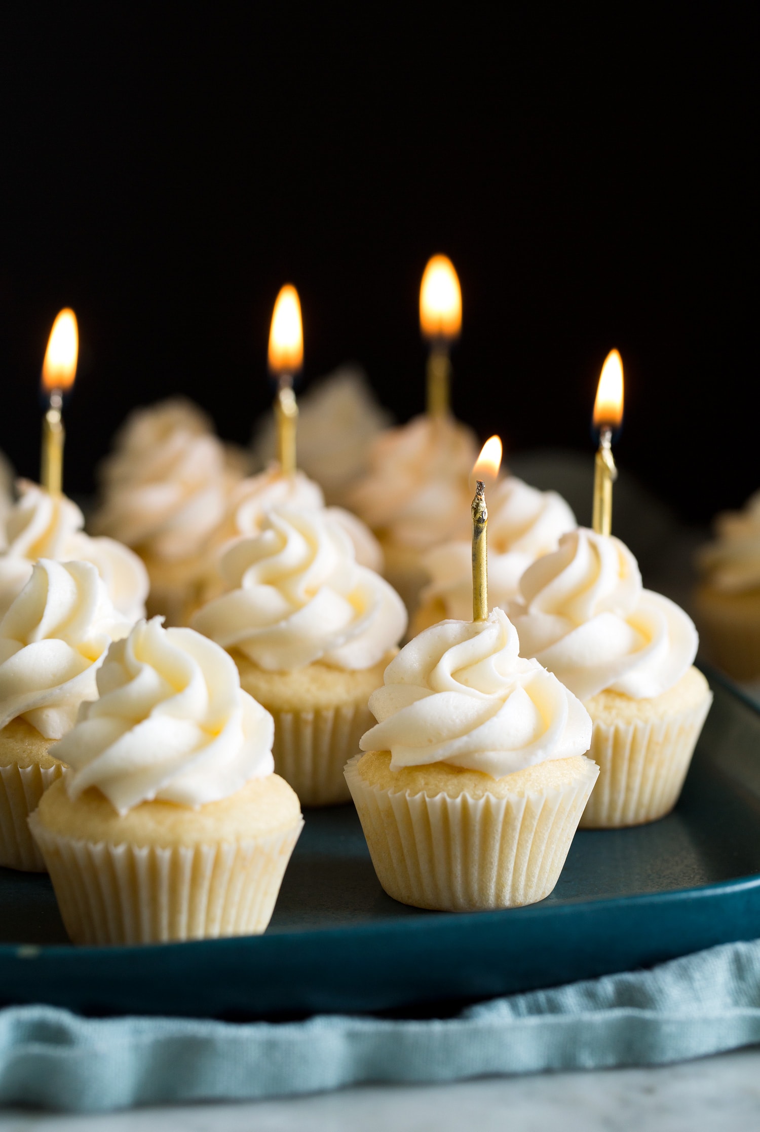 Mini cupcakes with mini lit birthday candles.