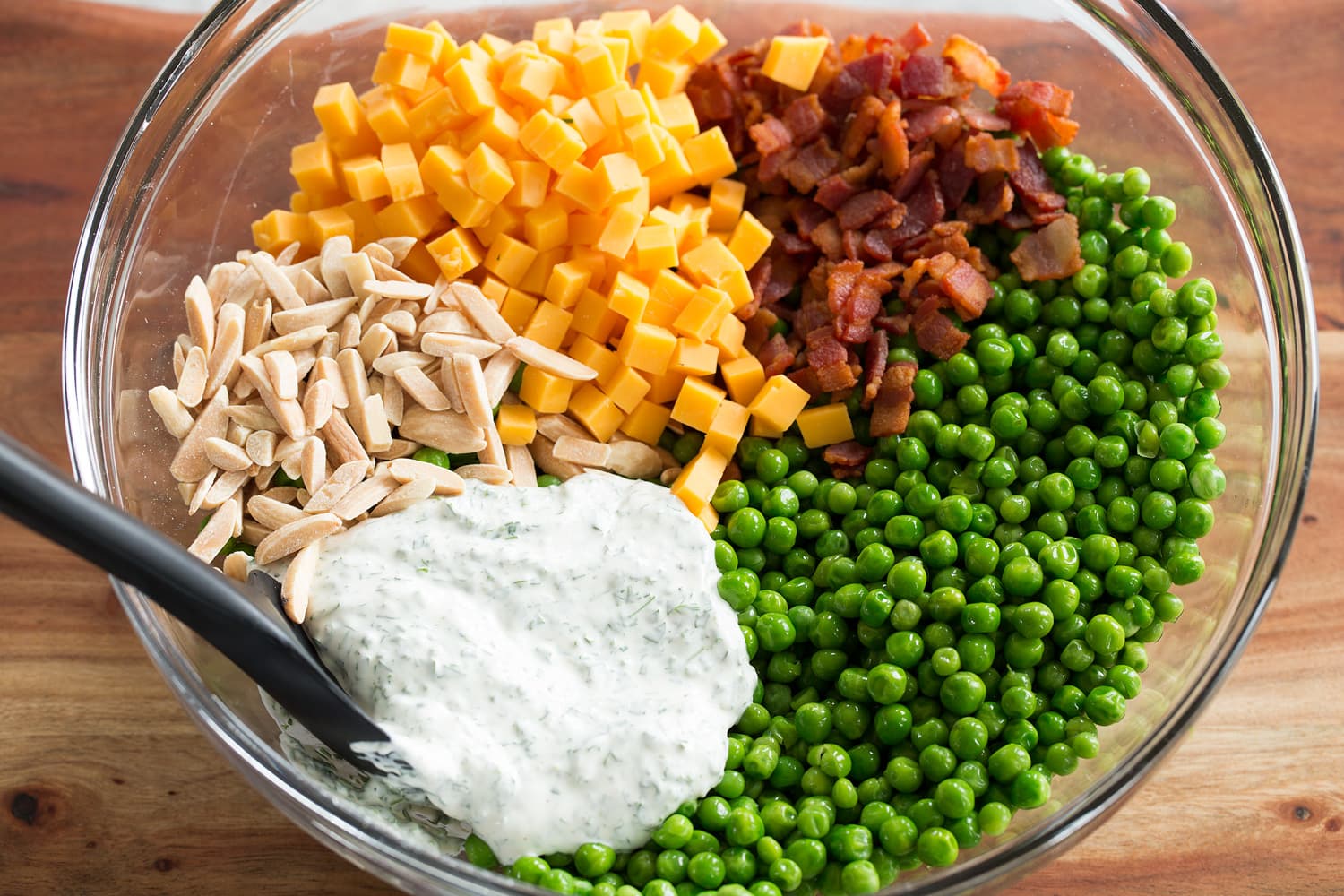 Pea salad prepared ingredients in a bowl shown before tossing.