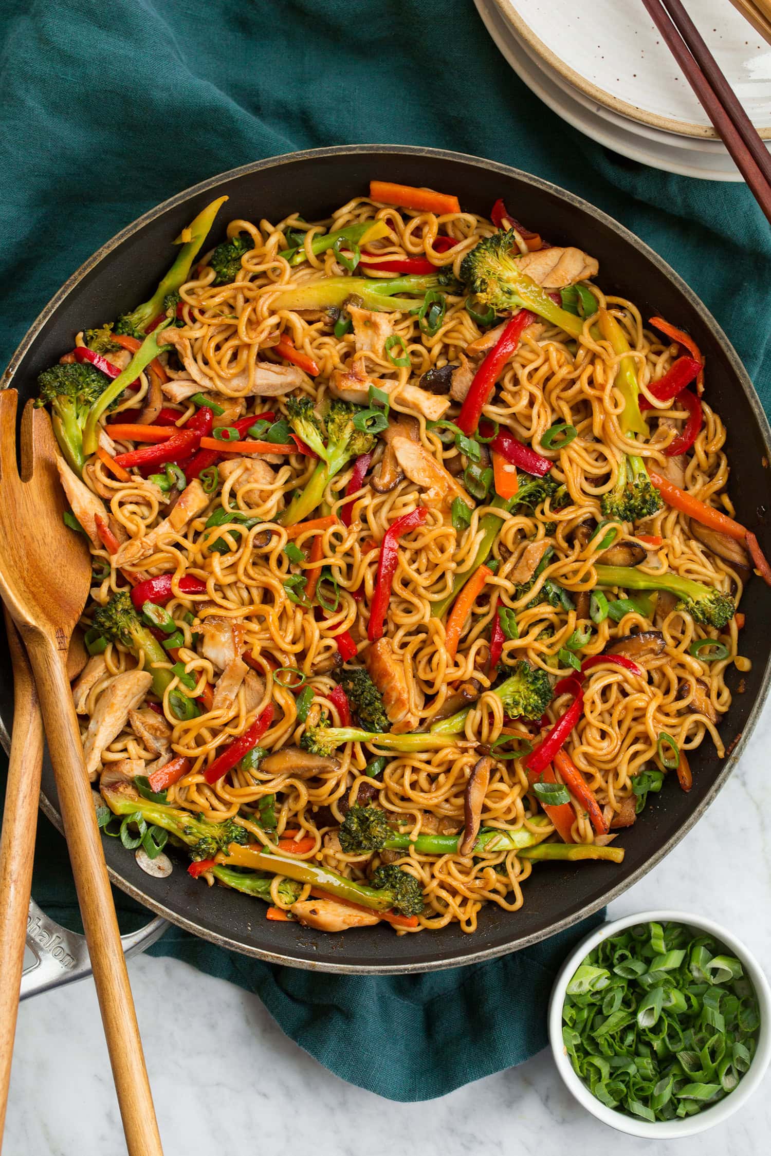 Photo du haut de nouilles sautées au poulet dans une grande poêle.