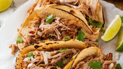 Pork carnitas shown in tortillas as tacos.