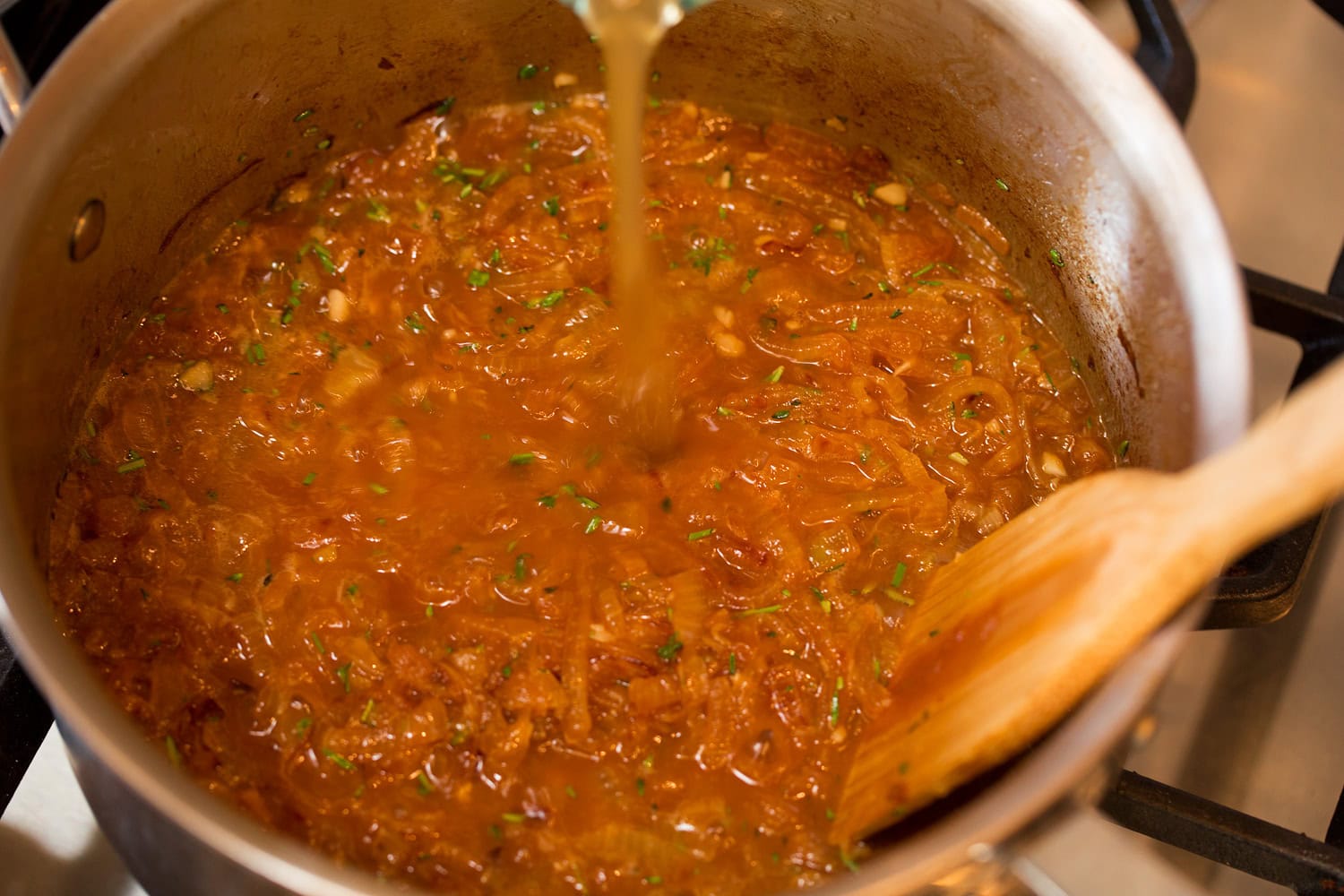 Chicken broth, wine and herbs added to caramelized French onions.