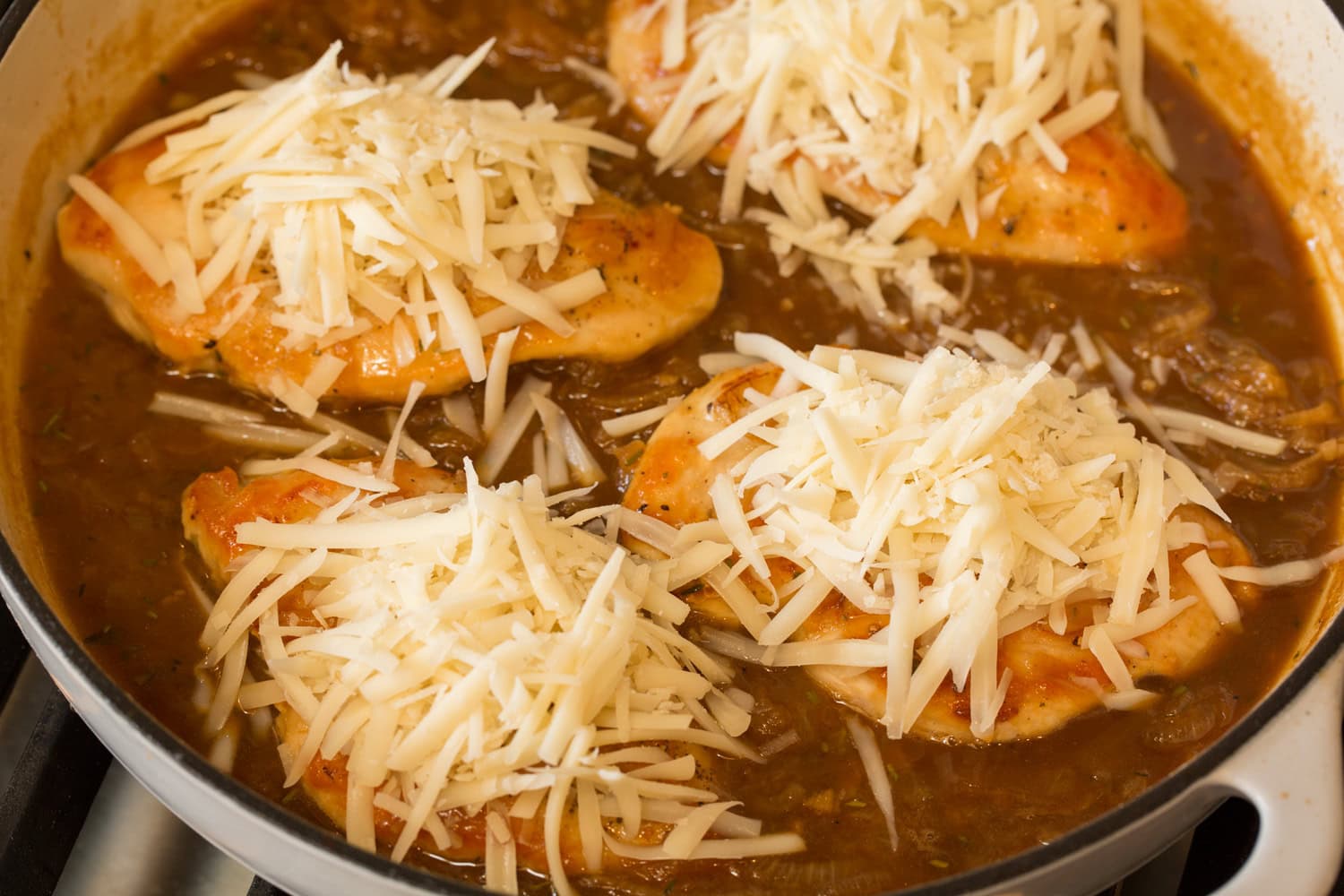 Grated cheese on chicken breasts before melting.