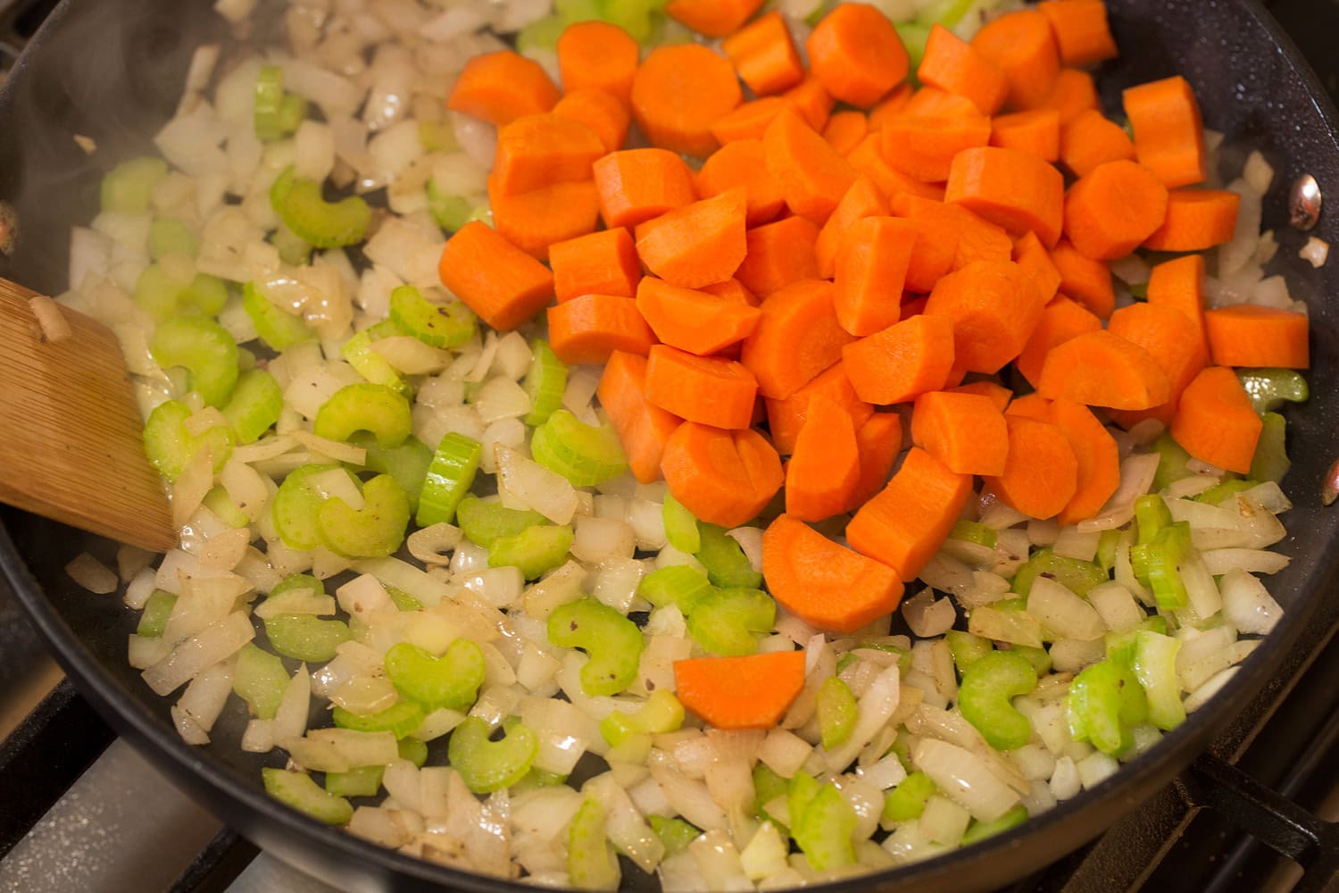 Carrots, celery and onions in a skillet sautéing. 