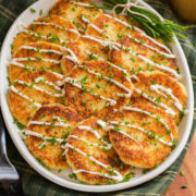 Potato cakes on a white oval platter over a green gingham cloth. - 1
