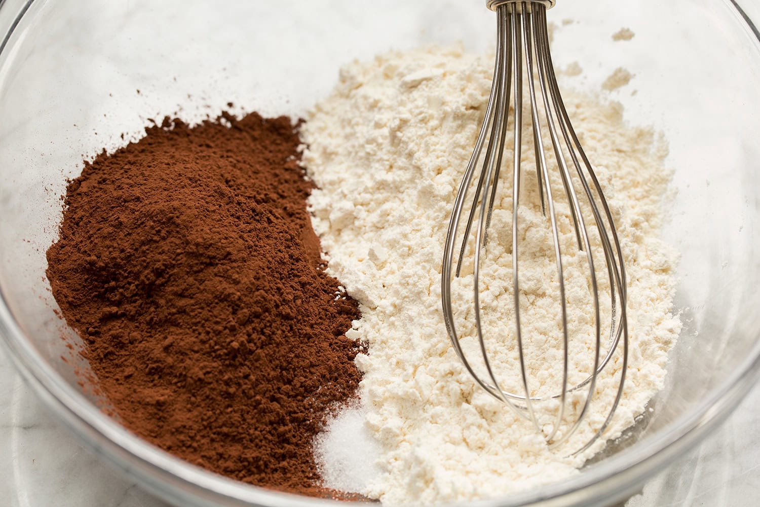 Whisking flour, cocoa powder and salt in a glass mixing bowl.