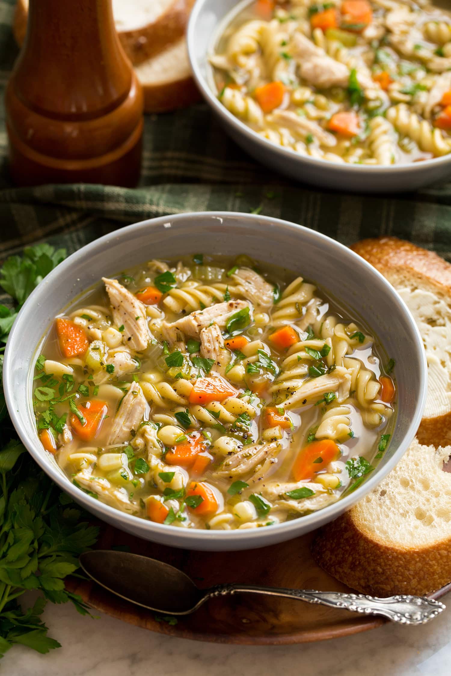 Serving of turkey noodle soup in a grey bowl.