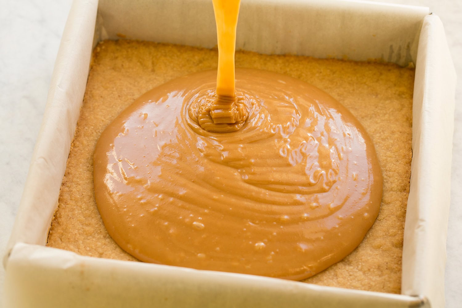 Versez le caramel sur la couche de biscuits.