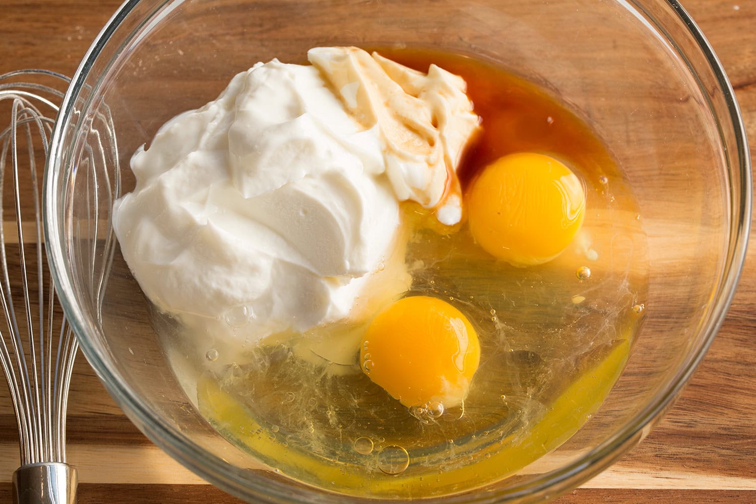 Greek yogurt and egg wet mixture for pancake batter in a mixing bowl.