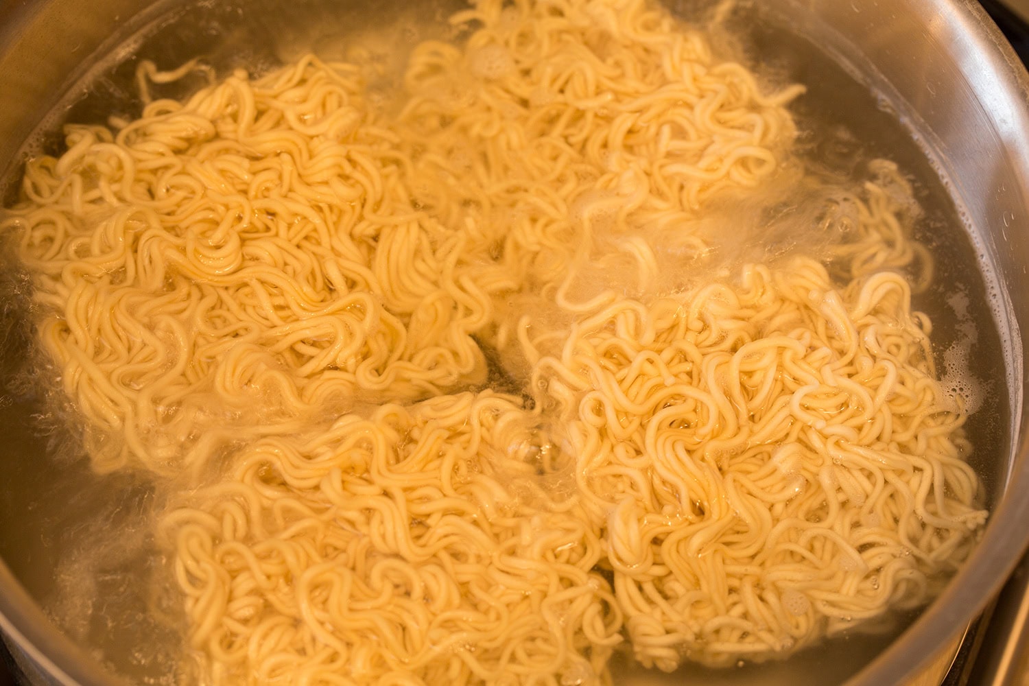 Nouilles ramen bouillies dans une casserole d'eau.