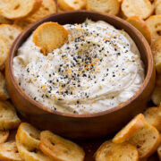 Everything bagel dip shown with homemade bagel chips on a platter. - 1