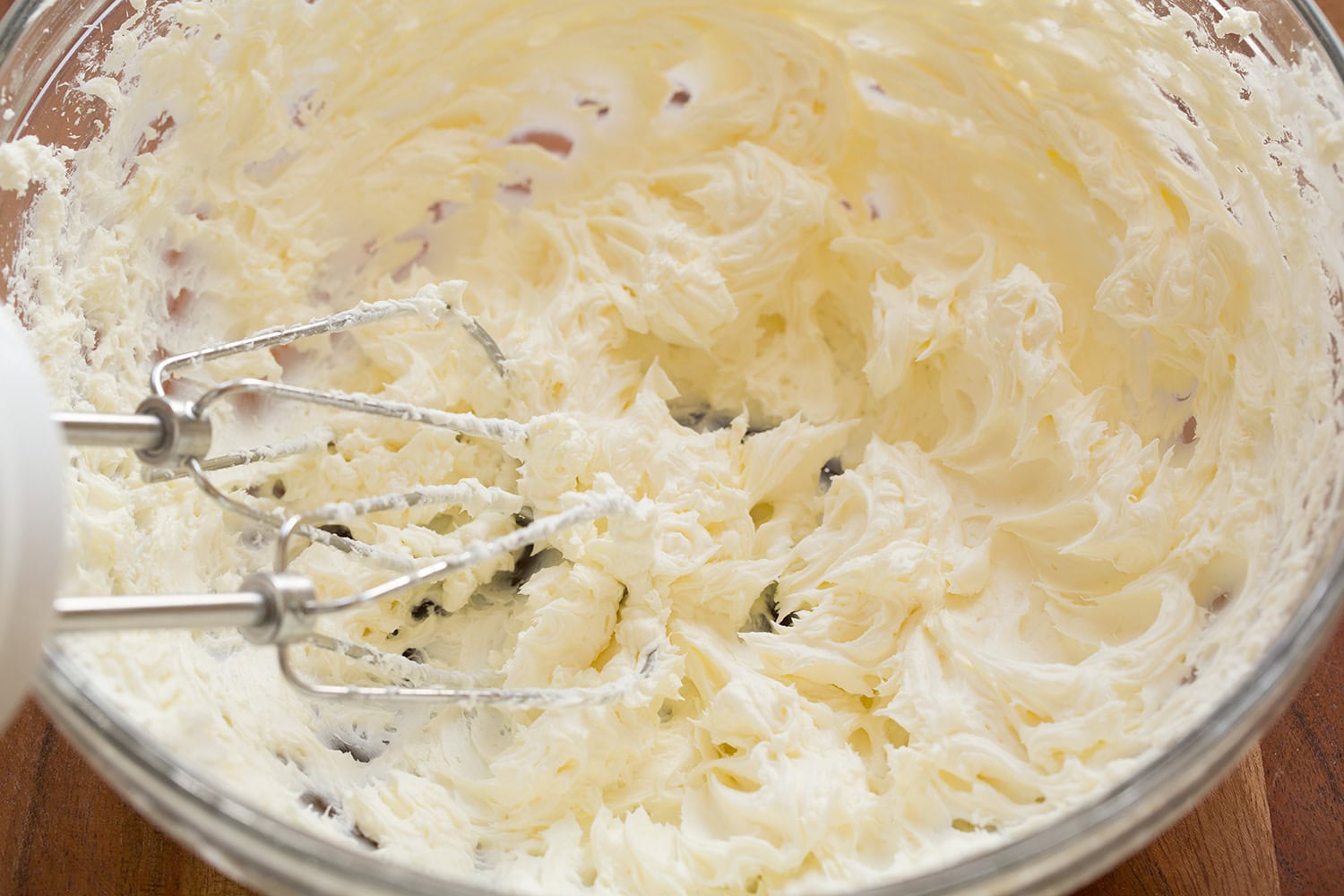 Cream cheese whipped until fluffy in a glass bowl.