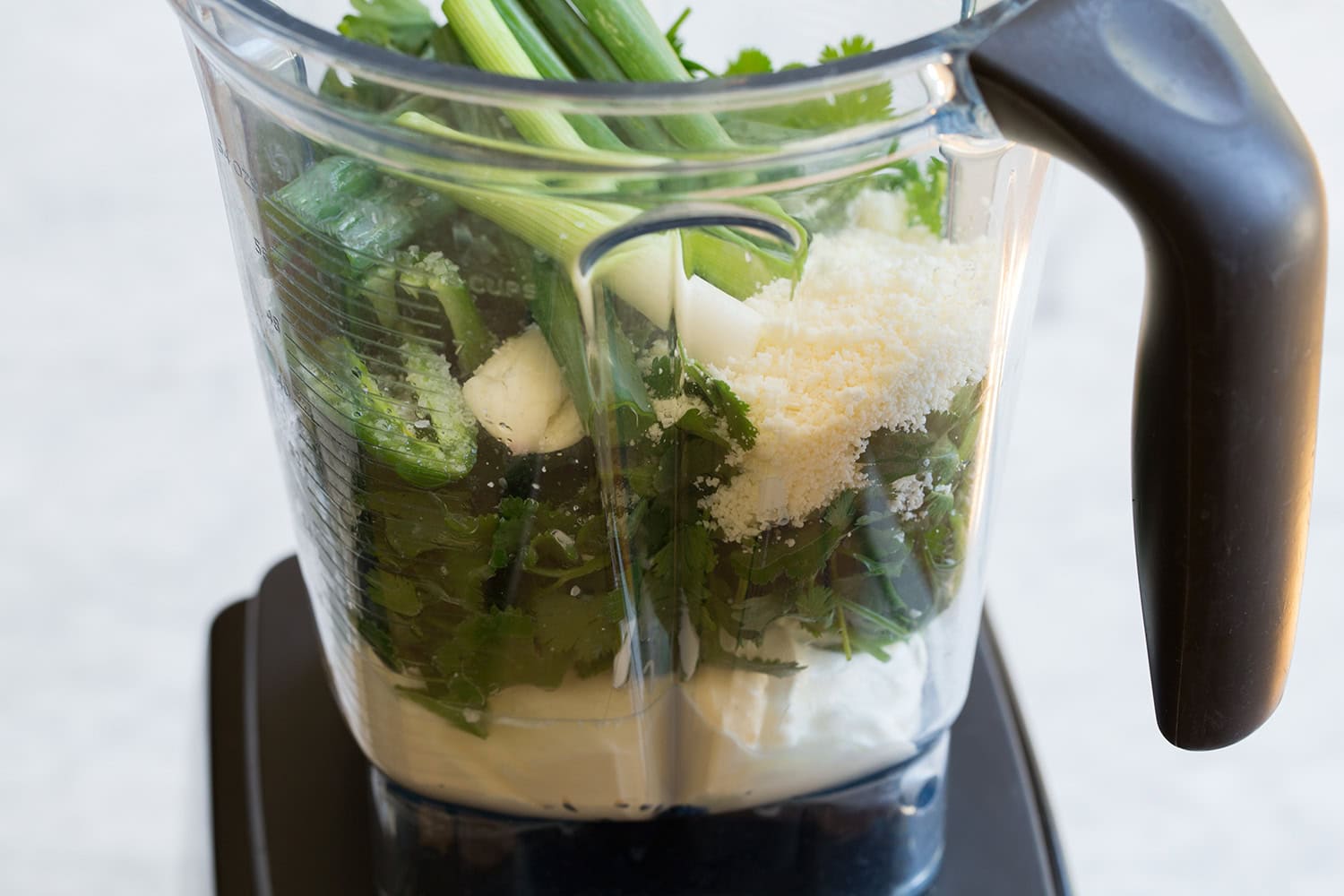 Aji verde ingredients shown prepped and added to a blender.