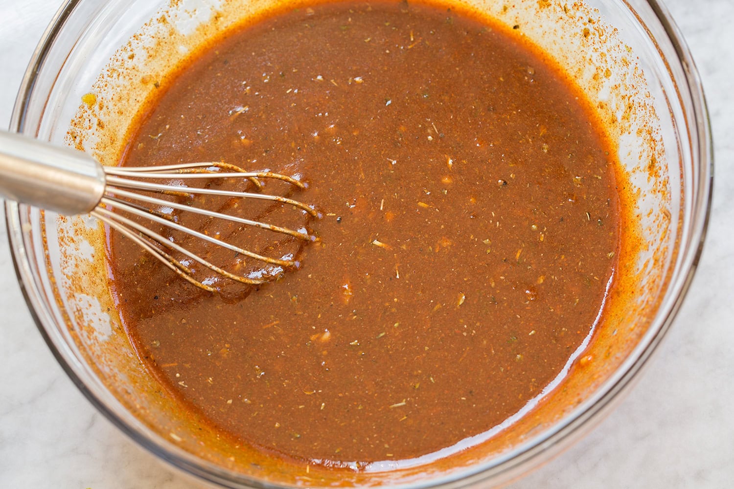 Peruvian chicken marinade whisked together in a glass mixing bowl.