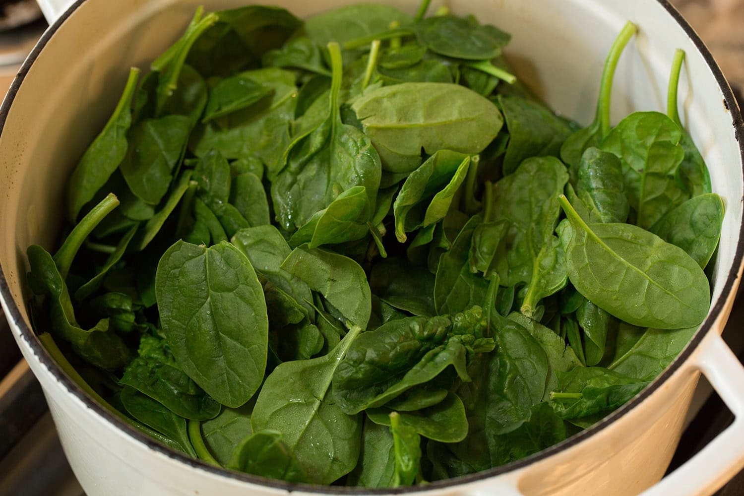 Spinach Soup Raw spinach added to pot.