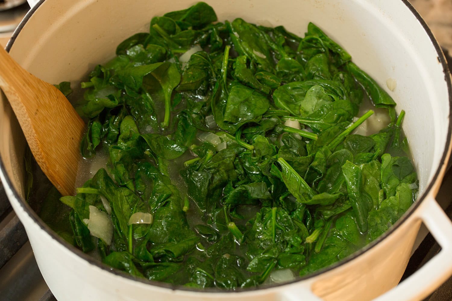 Spinach Soup Spinach shown wilted in pot on the stove.