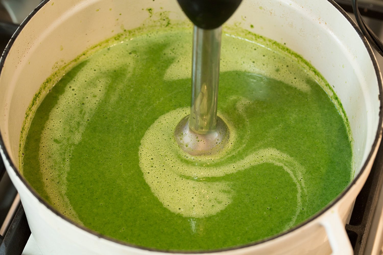 Spinach Soup Spinach soup shown being pureed with an immersion blender until smooth.