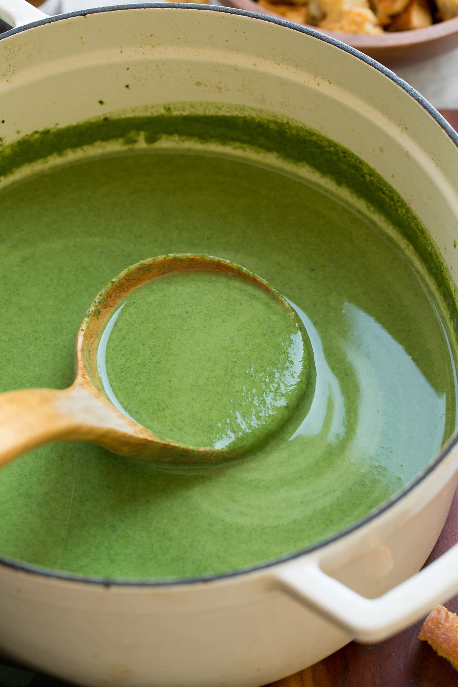 Spinach Soup Close up photo of wooden ladle full of spinach soup.