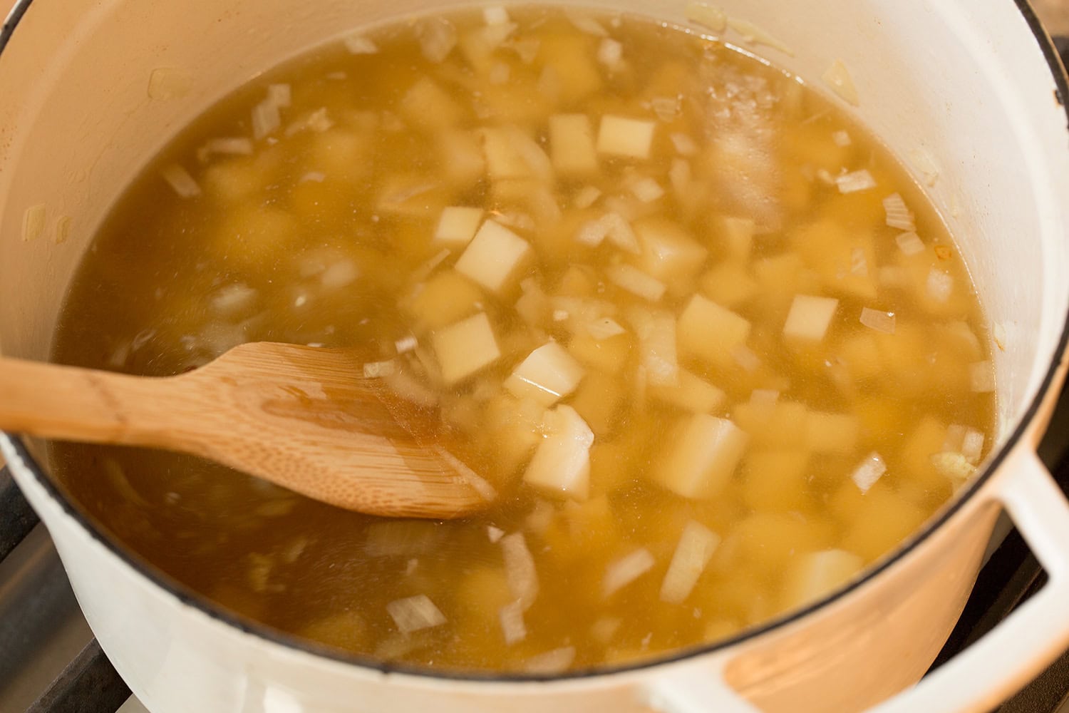Spinach Soup Cubed potatoes and chicken broth added to pot.
