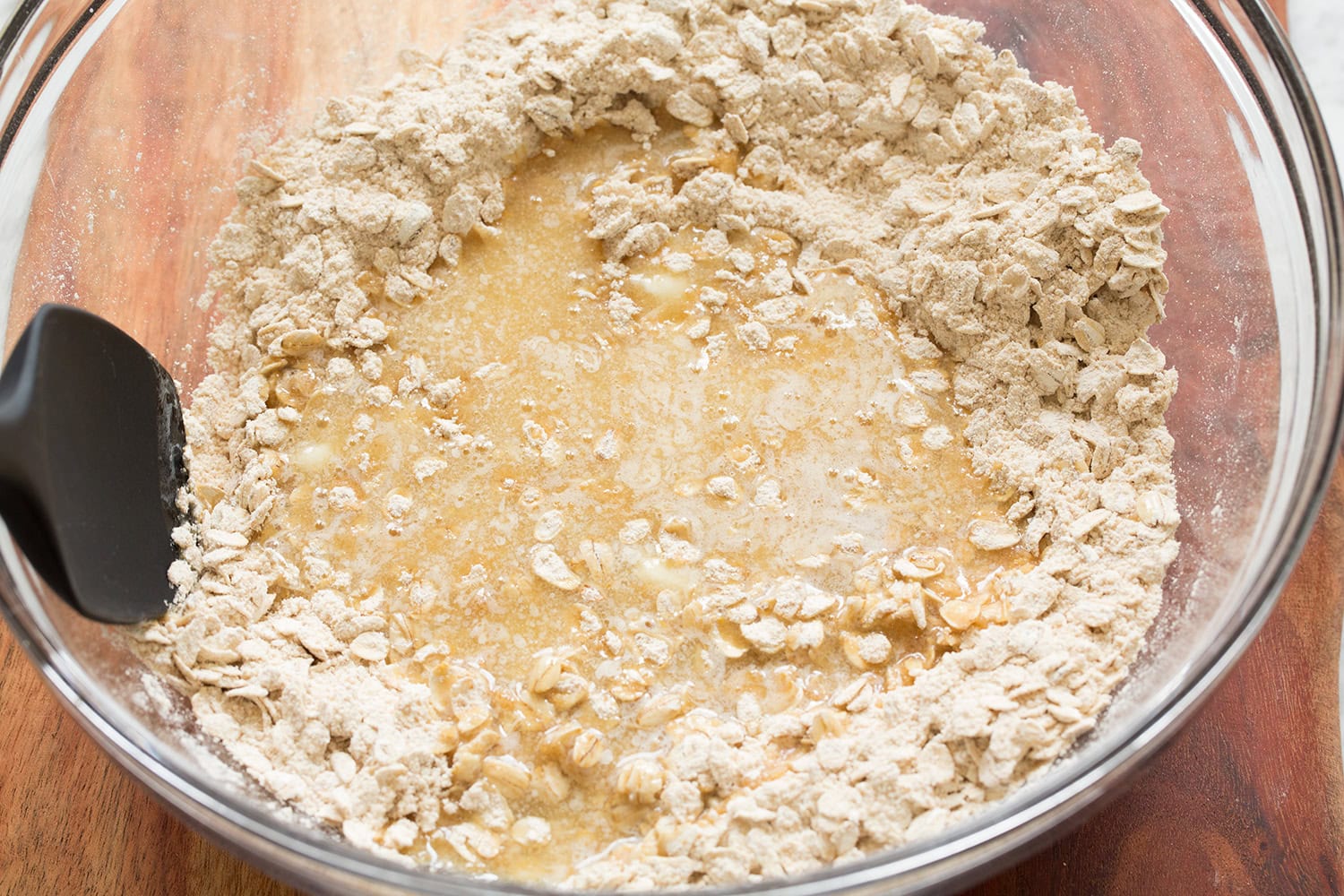 Butter added to oat flour mixture in mixing bowl.