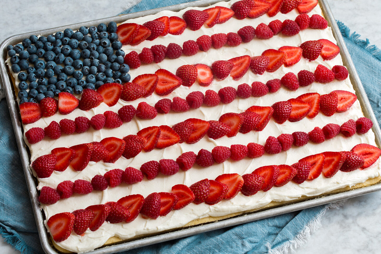 American flag sheet cake with white frosting strawberry stripes and blueberry star field for 4th of July celebration cake