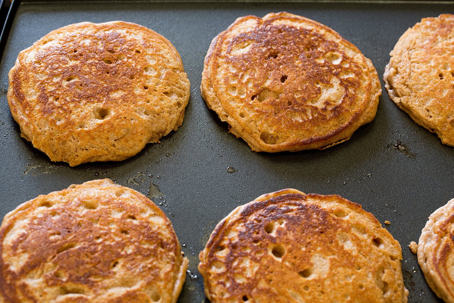 Cinnamon Roll Pancakes Cinnamon roll pancakes shown after flipping and cooking on second side on griddl.e