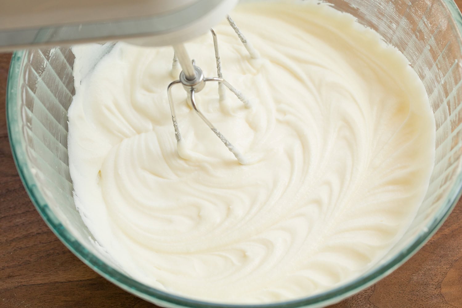 Cinnamon Roll Pancakes Completed cream cheese icing mixture in glass mixing bowl.