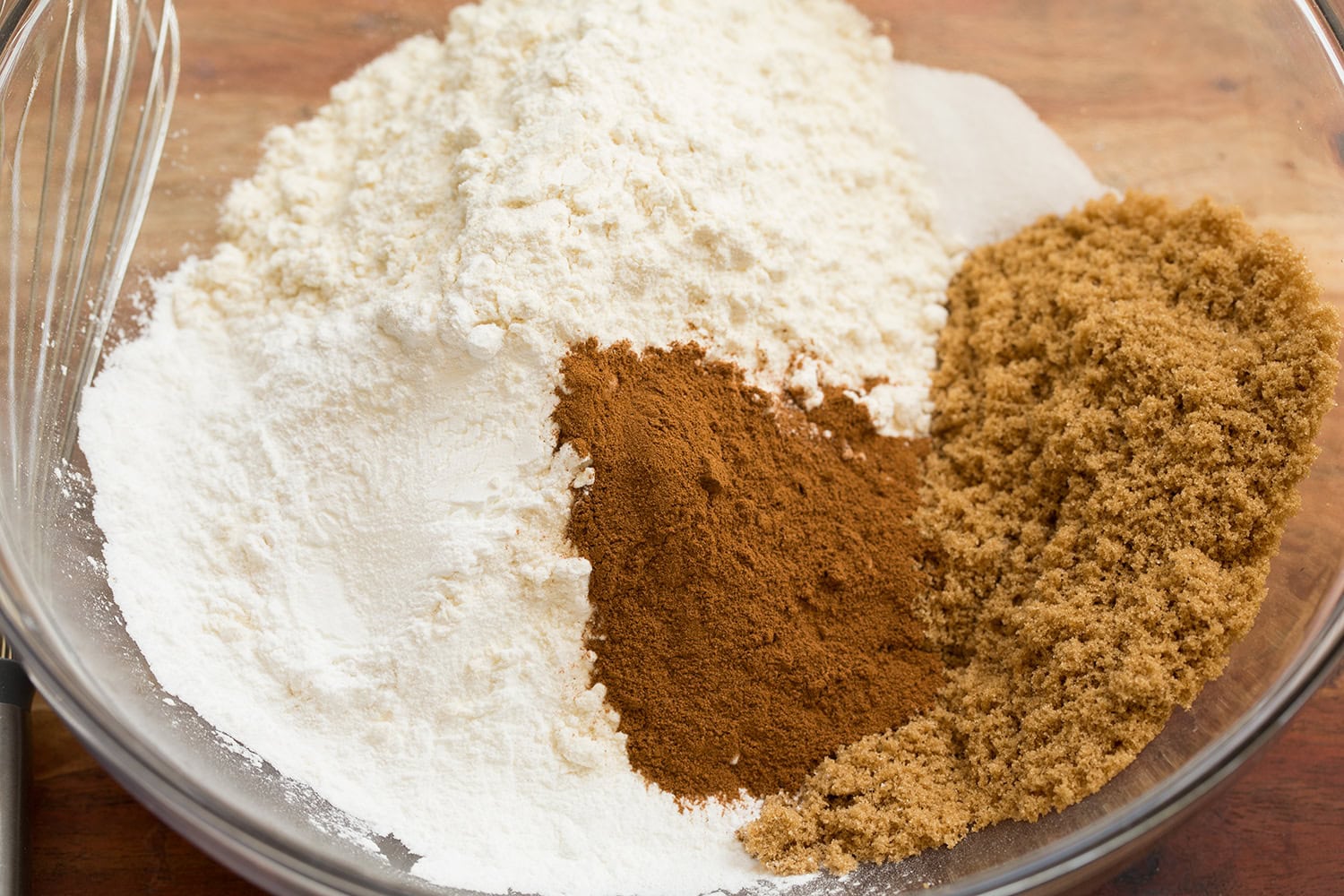 Cinnamon Roll Pancakes Flour, baking powder, salt, cinnamon and brown sugar shown in a glass mixing bowl before mixing.